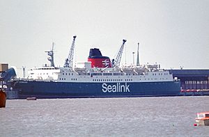 side view of a ship with dark bue hull, white superstructure and red funnel