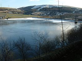 A frozen dam, the dam head and hills beyond