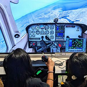 Visitors using a desktop flight simulator at Hiller Aviation Museum