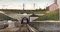 A postcard with a frontal view of a train emerging from a tunnel