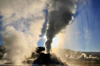 Steam phase eruption of Castle Geyser with crepuscular rays and shadow