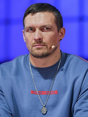 Oleksandr Usyk seated, wearing a microphone
