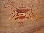 Rock painting in red of a four legged animal, a smaller four legged animal and a human figure.