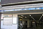 A brown-bricked building with a rectangular, light blue sign reading "STOCKWELL STATION" in white letters all under a light blue sky