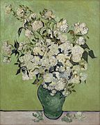Pale pink roses in a green vase, against a pale green background.