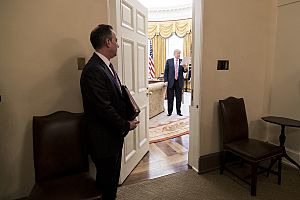 Chief of Staff Reince Priebus looks into the Oval Office as President Donald Trump reads over his notes, March 2017