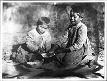 Two Havasupai Indian children, the daughters of Chickapanagie's, enjoy a mellon, ca.1900 (CHS-3362)