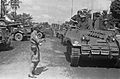 Een groep Recce M3 Stuart tanks passeert geparkeerde vrachtwagen. Bestanddeelnr 5740