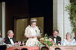President Ronald Reagan, George Shultz, and Helena Shultz laughing at remarks by Queen Elizabeth II