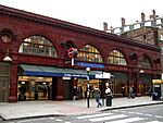 A red-bricked building with a rectangular, dark blue sign reading "RUSSELL SQUARE STATION" in white letters all under a white sky