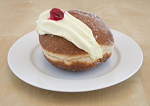 Kitchener bun with cream on a plate.