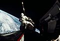 Astronaut Richard Gordon attaches a tether line from his spacecraft to Agena