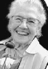 A smiling older white woman, wearing glasses.