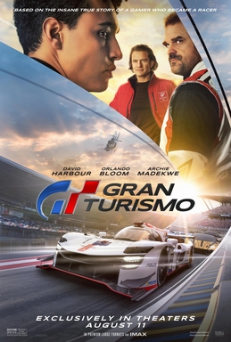A young man stands in front of the front side of a car, which is surrounded by two other men standing on the left and right sides of it. The film's title and release date are centered at the bottom of the poster, with the tagline "From Gamer to Racer" centered at the top.