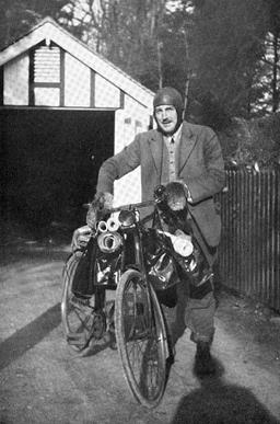 Photograph of a man with a bicycle.