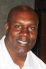 David Fulcher smiling while wearing a white polo shirt.