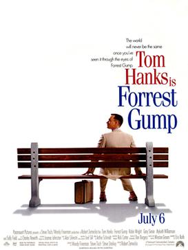 Film poster with a white background and a park bench (facing away from the viewer) near the bottom. A man wearing a white suit is sitting on the right side of the bench and is looking to his left while resting his hands on both sides of him on the bench. A suitcase is sitting on the ground, and the man is wearing tennis shoes. At the top left of the image is the film's tagline and title and at the bottom is the release date and production credits.