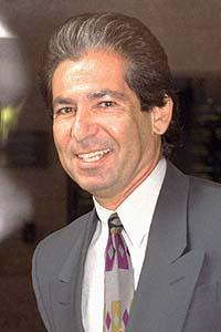 Robert Kardashian smiles at the camera, dressed in a suit