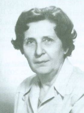 Black and white portrait of a middle-aged 20th century woman dressed in a collared-shirt.