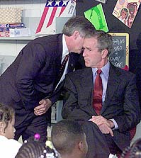 Andrew Card discretely telling US President George W. Bush about the September 11 attacks