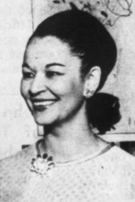 A smiling, light-skinned African-American woman with hair dressed back to the nape, wearing a large brooch at her throat