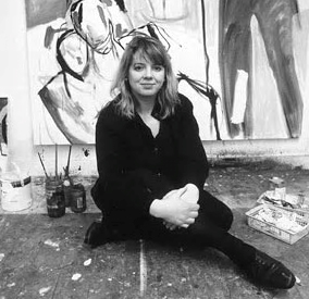 black and white photograph of Caroline McNairn, sitting on the floor in her studio