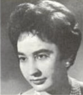A light-skinned woman with short dark bouffant hair and dark eyes