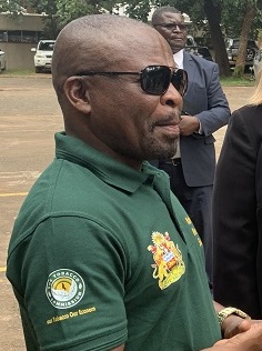 Headshot of Michael Usi in sunglasses and a green shirt