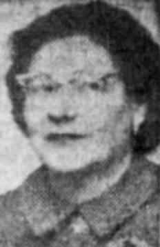 A newspaper photo of a woman with dark coiffed hair, wearing cat-eye glasses and a dark suit