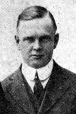 Head and shoulders of white middle-aged man in 1920s suit and tie