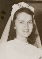 A smiling young white woman wearing a bridal veil.