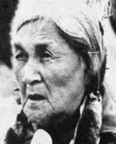 An elderly Siksika woman, grey hair parted and in braids, from a 1988 newspaper