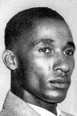 A black and white photograph of a young blank  man with short hair in tight closeup.