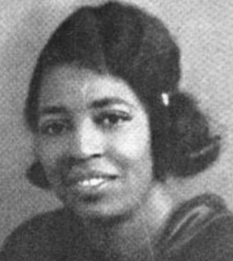 A young African-American woman, her hair cut to chin-length and caught in a barrette at the side. She is smiling, and wearing a dark blouse or dress.