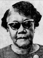 An older African-American woman wearing dark cat-eye glasses. Her hair is cut short and parted on the side.