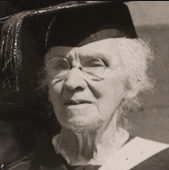 a photograph of an older white woman wearing an academic cap and glasses.