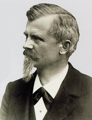 Black-and-white photo of a middle-aged man with a beard and moustache