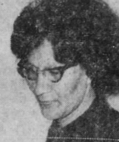 A Native American woman with dark hair in a bouffant hairstyle, wearing cat-eye glasses