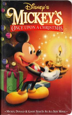 Mickey Mouse is standing at the left side of the image is holding a candle holder with a brightly burning candle, positioned on the right side of the image, with both of his hands. Mickey is wearing his traditional red shorts with white buttons and yellow shoes and as usual, is happily smiling. In the background on the left side of the picture stands a decorated Christmas tree with colorfully wrapped gifts lying under it. The video cover includes the film and company's title.