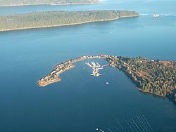 Aerial view of Deep Bay Marina with Baynes Sound, Denman Island (Chrome Island Light off its tip) and Hornby Island in the background.