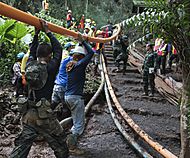 4547274 Thai rescue workers positioning a pipe for the pumping operation in the Tham Luang cave
