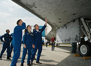 The STS-121 crew gets a close look at the underside of the orbiter Discovery after landing