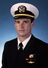 Top half of young man in circa 2000 dress U.S. Navy uniform of junior officer.