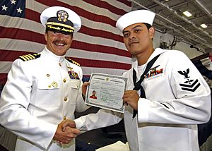 US Navy 060614-N-1045B-044 Aviation Machinist's Mate Elmer Rayos, right, receives his certificate of United States citizenship from USS George Washington (CVN 73) commanding officer