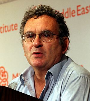 Benny Morris wearing light blue open-necked shirt, looking left of camera and appearing to speak
