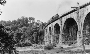 PHOTOCOPY OF PRE-1948 PHOTOGRAPH OF LOCOMOTIVE CROSSING VIADUCT WITH RELAY HOUSE IN BACKGROUND. Photo identified as Chemy negative no. 4257. Courtesy of the Smithsonian Institution HAER MD,14-ELK,1-18