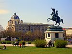 A large statue depicting a soldier riding a horse stands in the middle of a park.