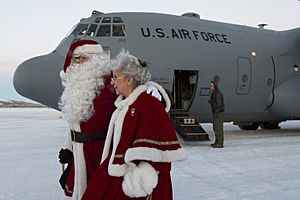 Santa and Mrs. Claus exit a C-130H Hercules aircraft at St. Mary's, Alaska, Dec. 5, 2015