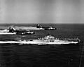 F9F-2 Panthers of VF-191 fly past USS Princeton (CV-37) off Korea, circa in May 1951 (NH 97047)