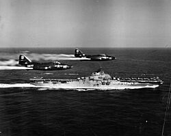 F9F-2 Panthers of VF-191 fly past USS Princeton (CV-37) off Korea, circa in May 1951 (NH 97047)
